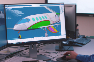Computer monitor displaying a 3D engineering assembly in CAD software with an AI assistant interface for design review and model analysis